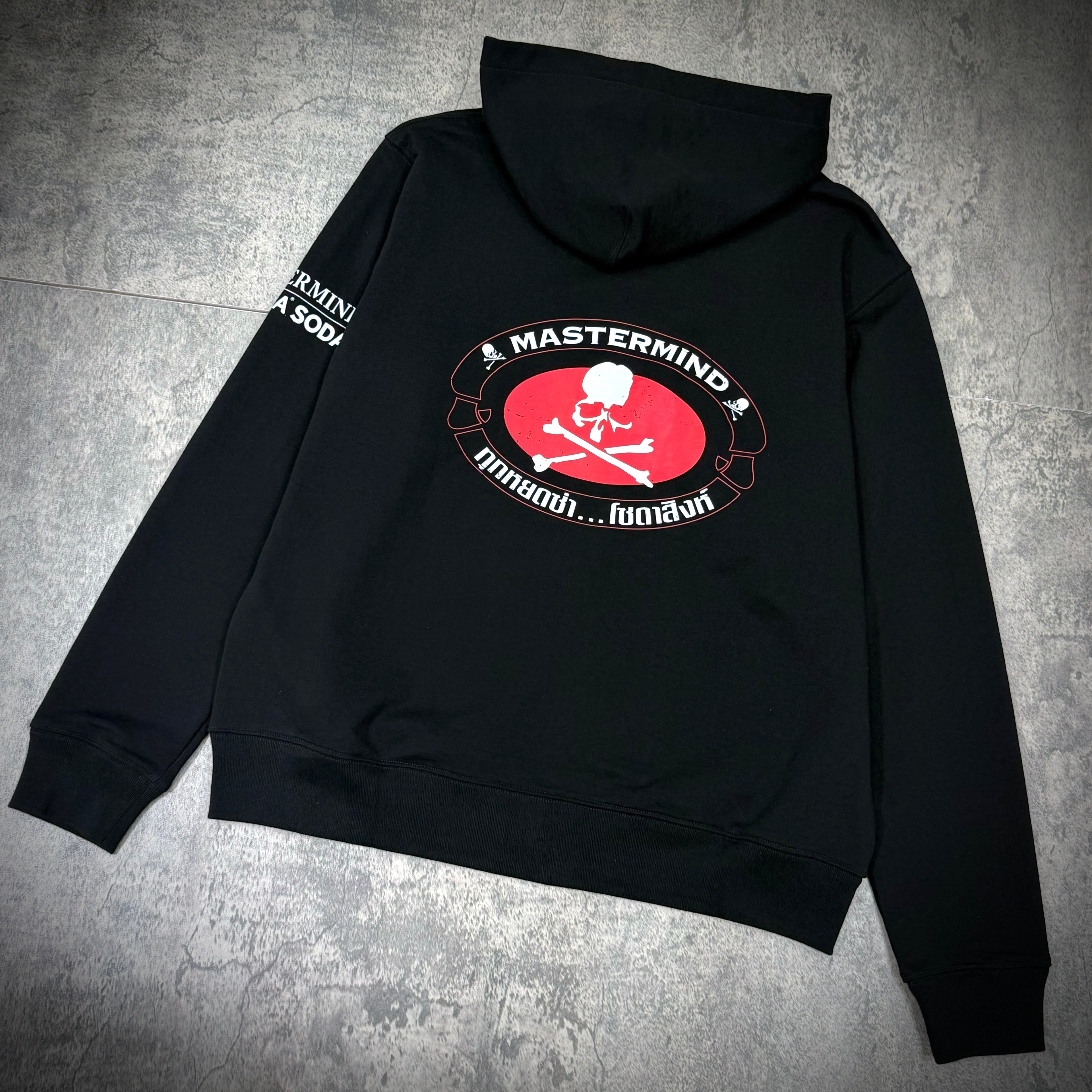 Singha Soda x Mastermind World Zip Up Hoodie featuring bold graphic design and black fabric, ideal for casual style.