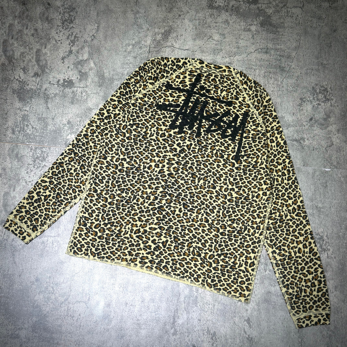 Stussy Basic Raglan Thermal LS Crew FW26 in leopard print with black logo on back, long sleeve style.