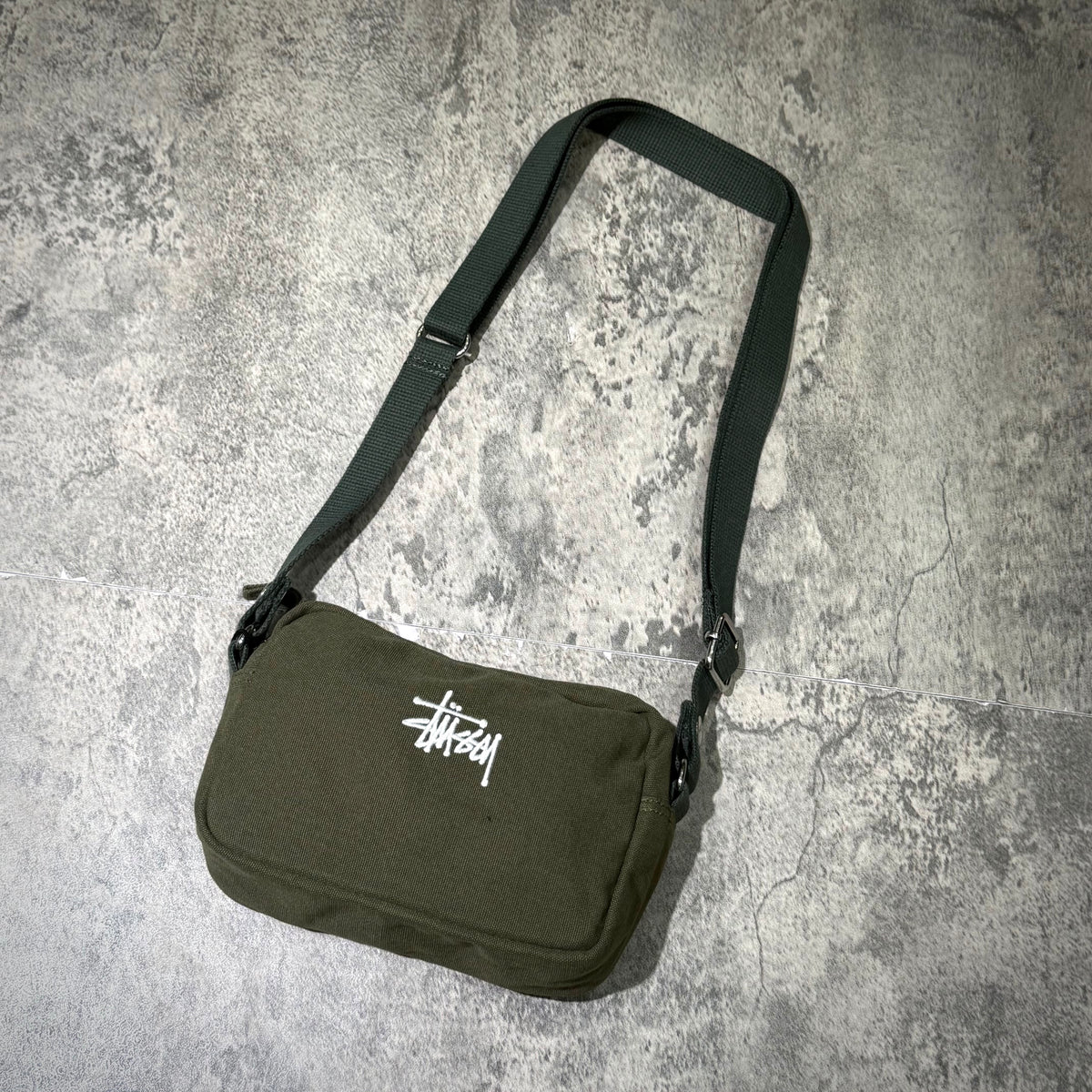 Stussy Canvas Side Pouch in olive green with adjustable strap and logo, perfect for casual outings.