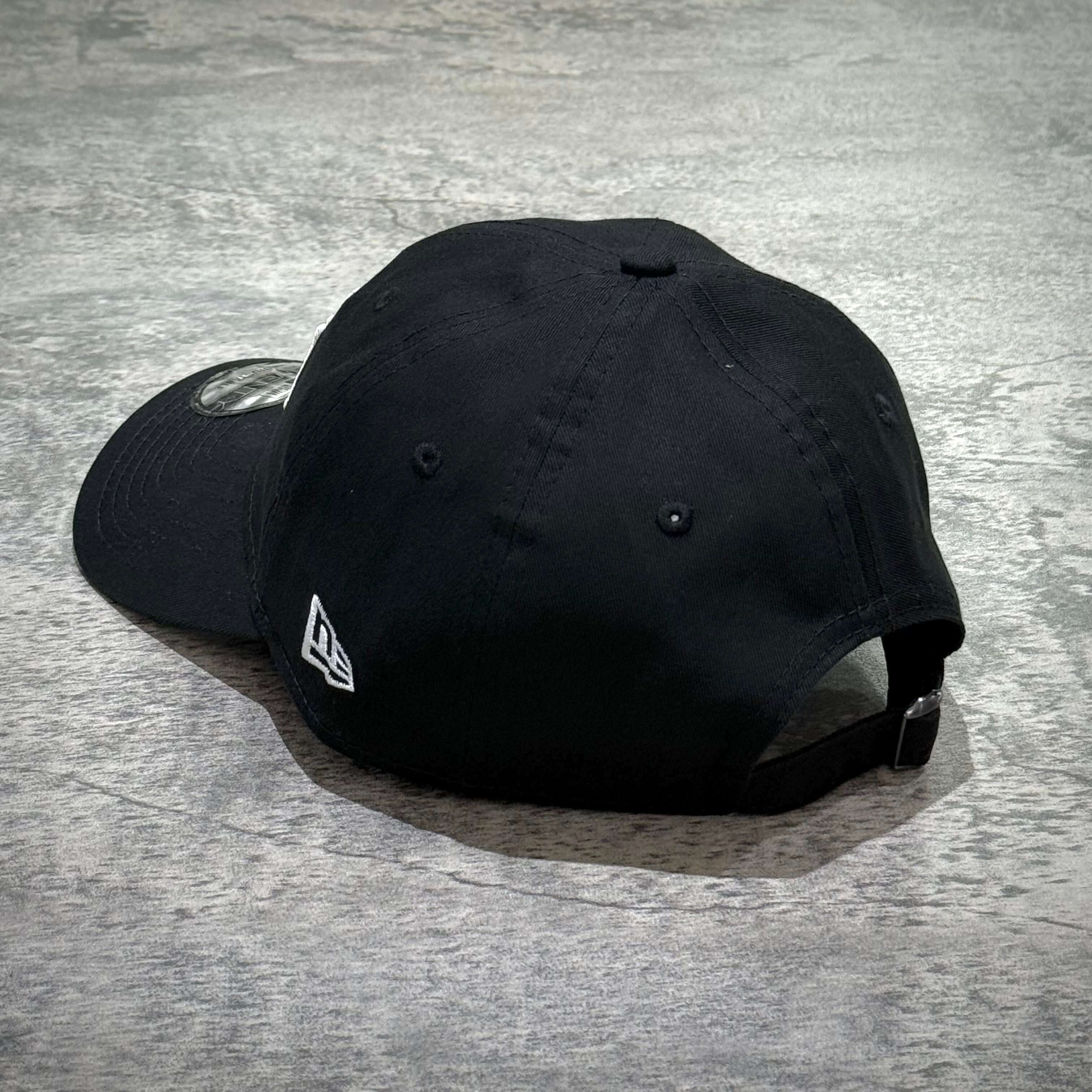 Stussy New Era 9Twenty Basic Strapback黑色帽子的背面視圖，顯示帽扣和標誌