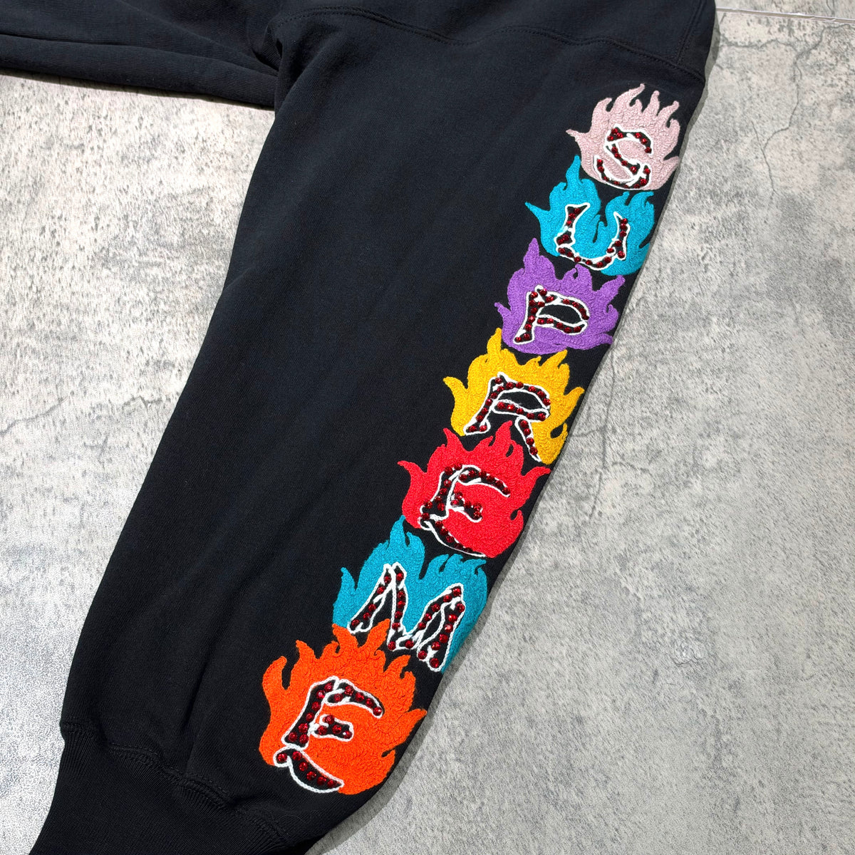 Supreme Fuck You Zip Up Hooded Sweatshirt black sleeve detail featuring colorful flame embroidery.