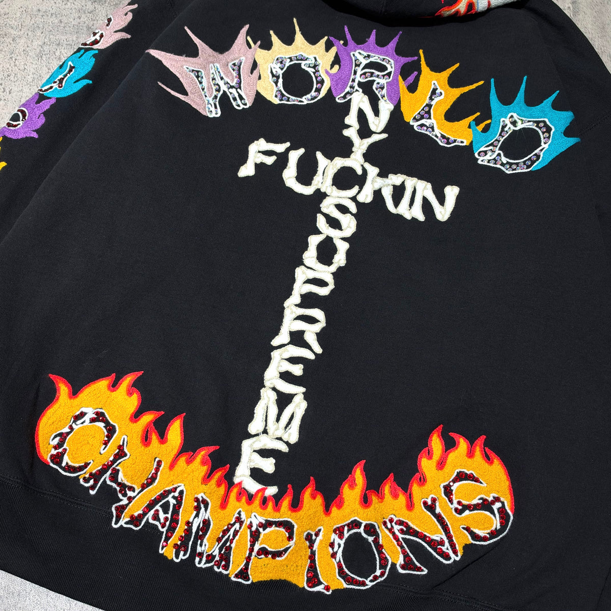Supreme Fuck You Zip Up Hooded Sweatshirt featuring bold 'WORLD FUCKIN SUPREME CHAMPIONS' graphic in vibrant colors on back.