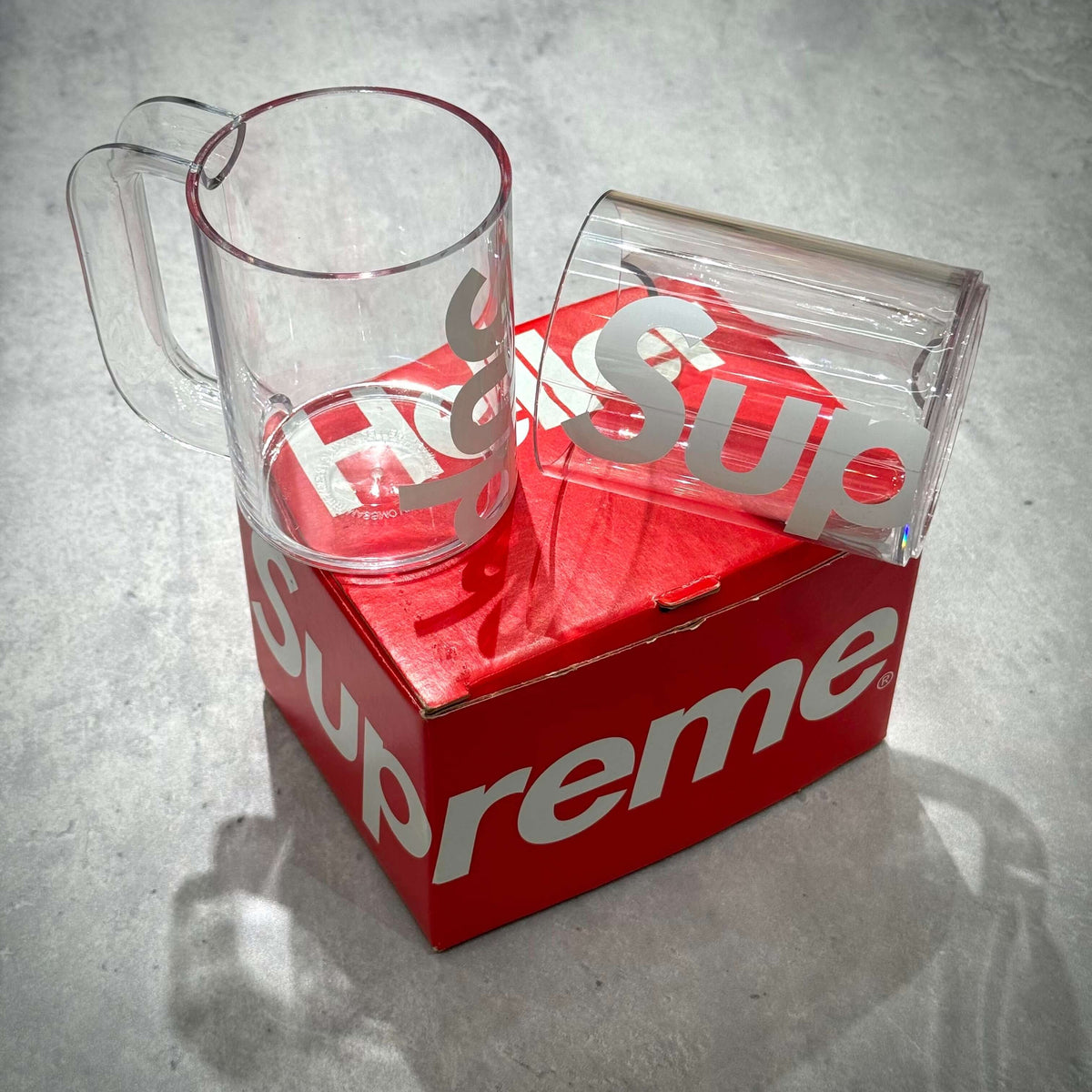 Supreme Heller Mugs Set of 2 - Clear displayed on a red box with the Supreme logo.