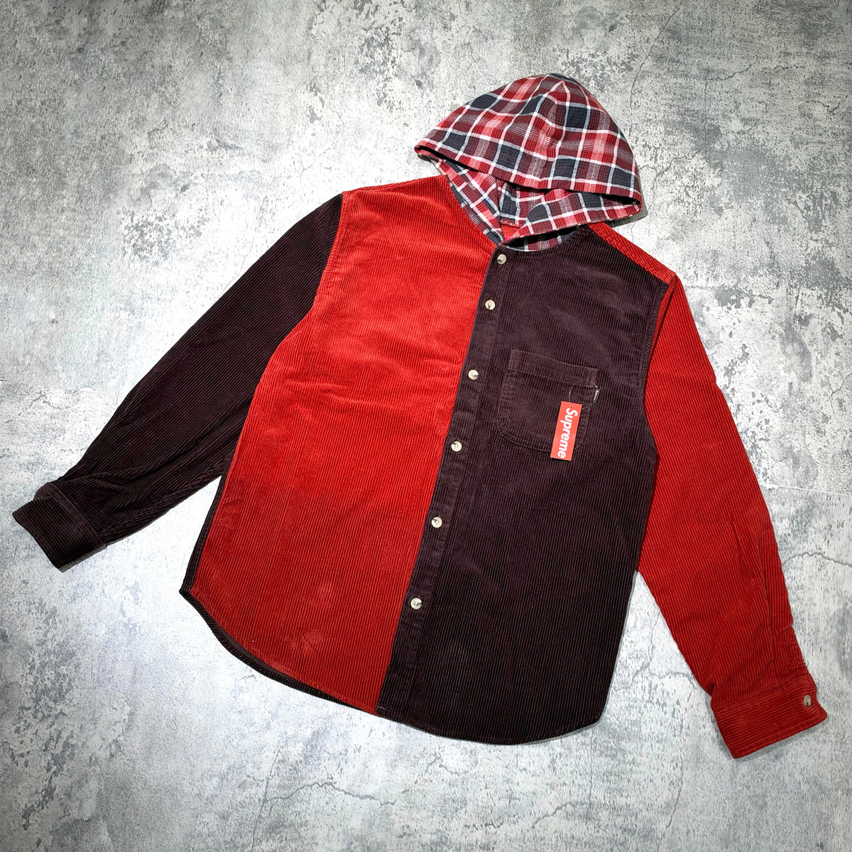 Supreme Hooded Color Blocked Corduroy Shirt featuring a plaid hood and a mix of red and dark tones.