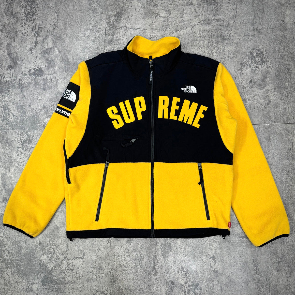 Supreme x The North Face Arc Logo Denali Fleece Jacket - Yellow displayed on a grey background.