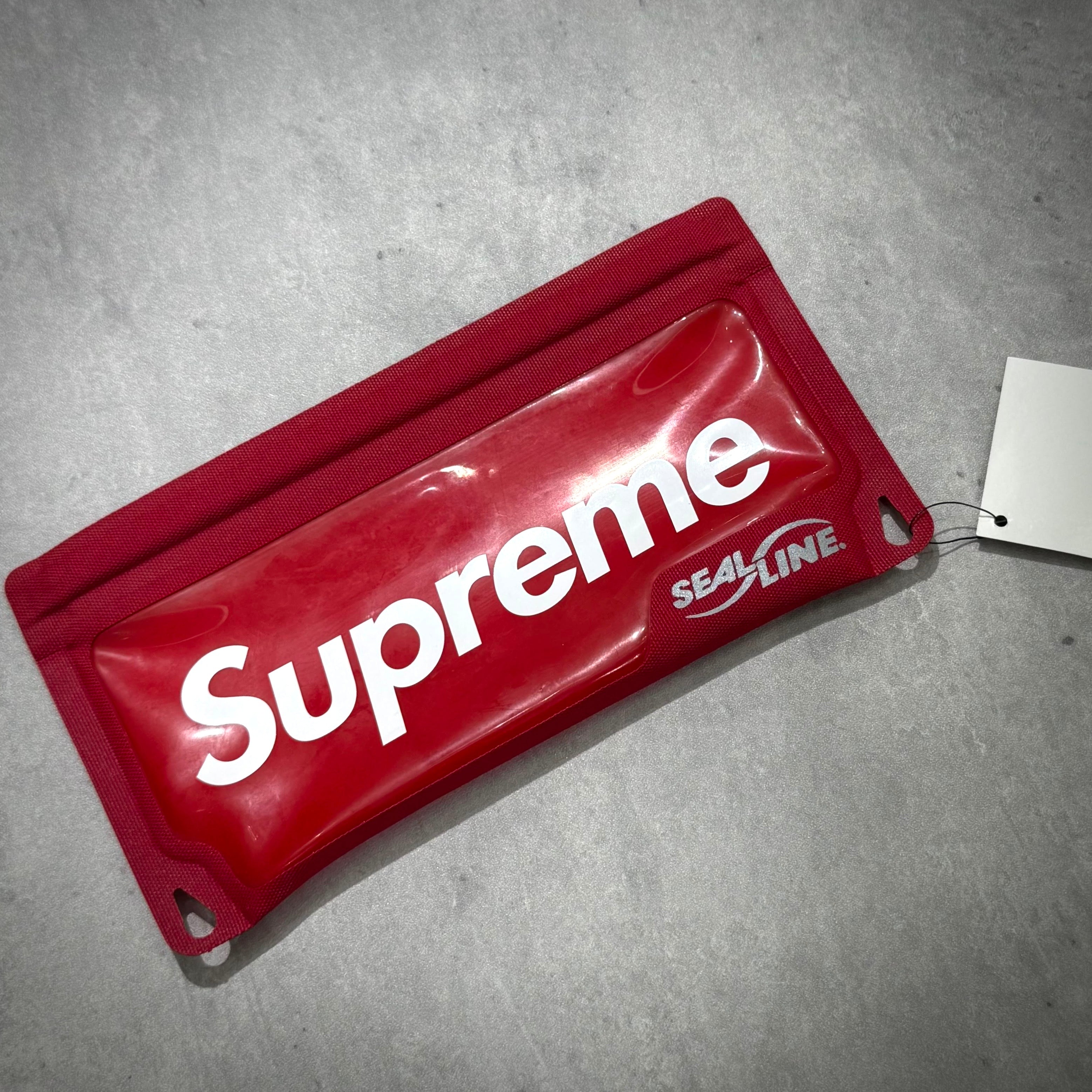 Supreme SealLine Waterproof Case in red color on a grey surface, showcasing brand logo and design details.