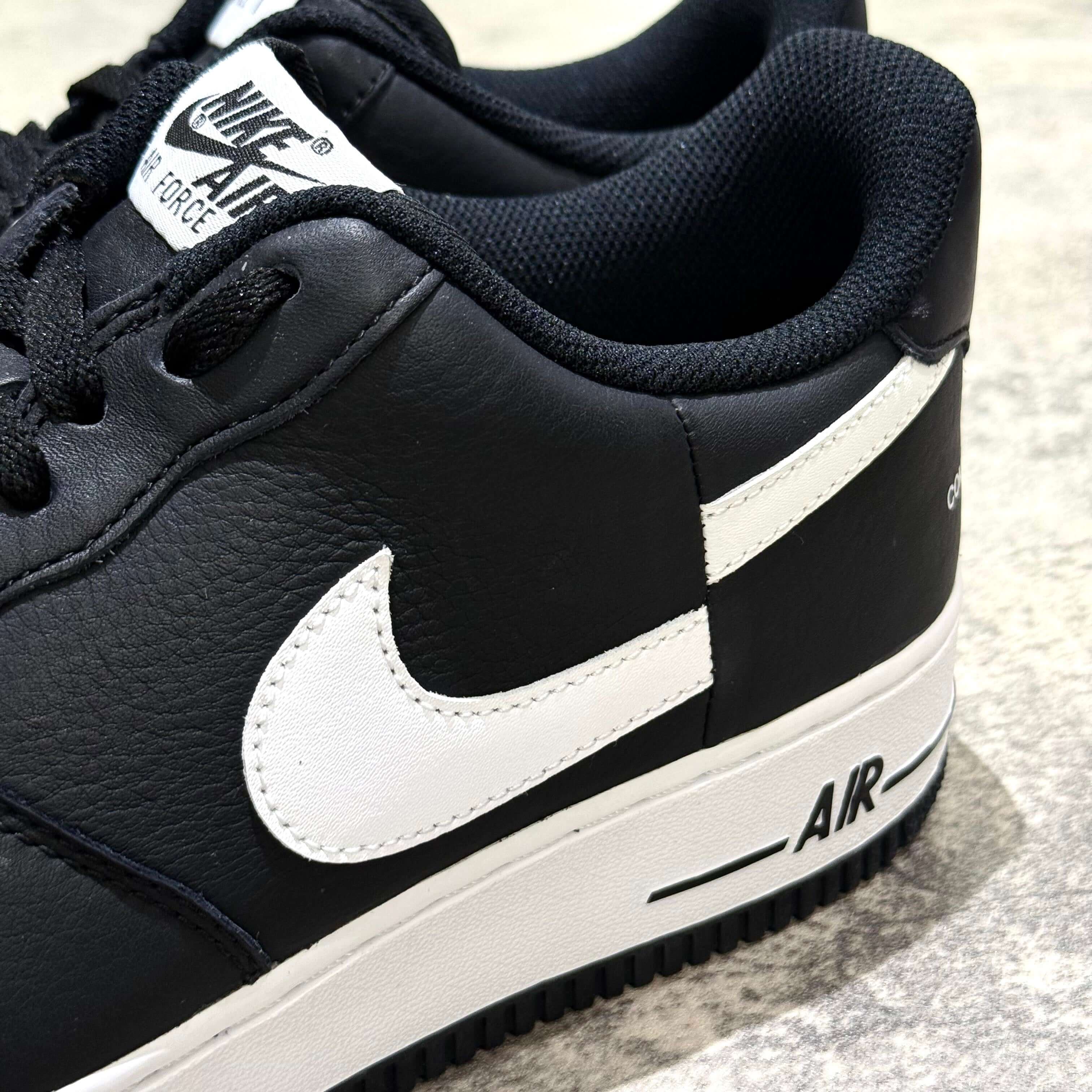 Close-up view of the Supreme x Comme des Garçons x Nike Split Logo Air Force 1 Low sneaker showcasing its sleek black design and signature Nike swoosh.