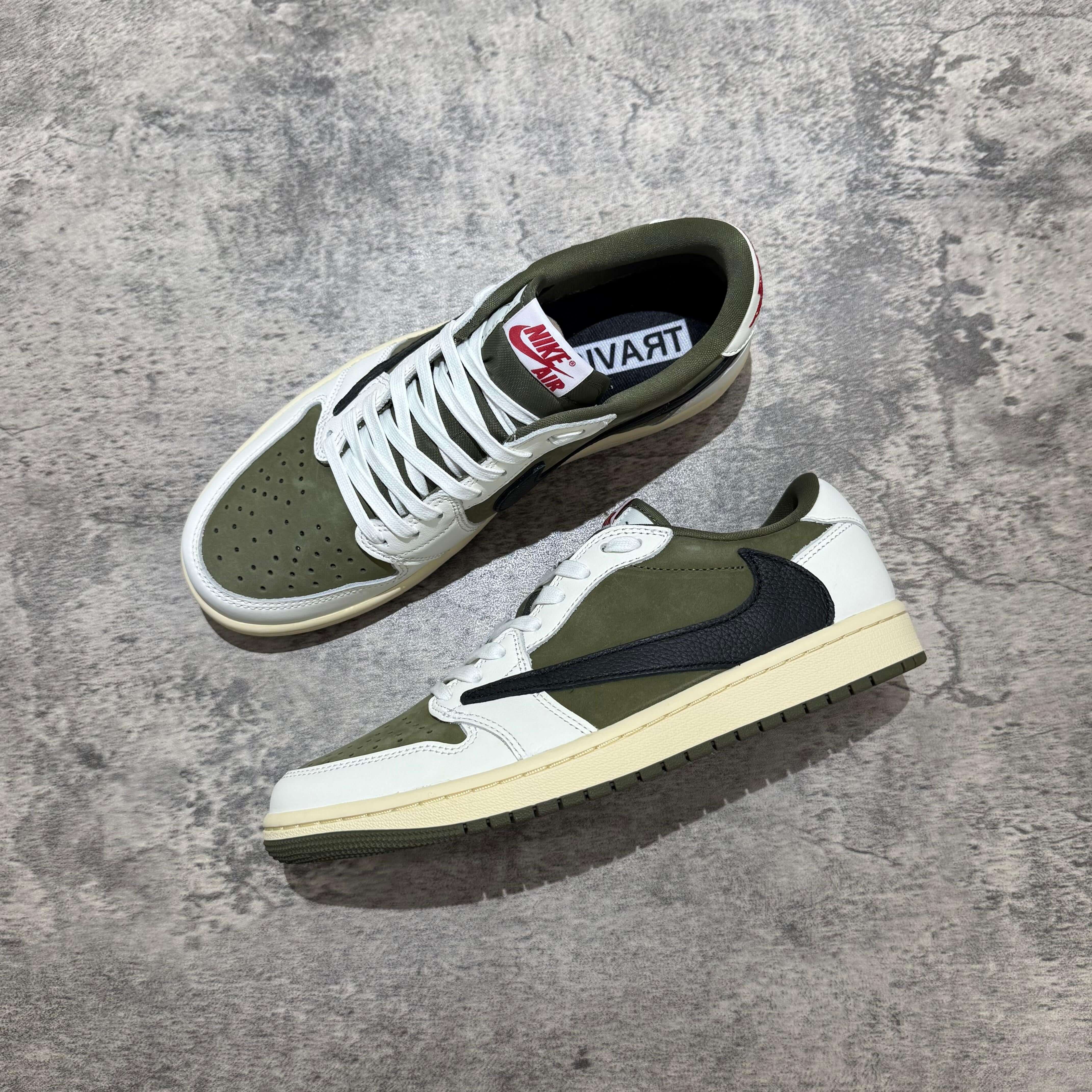 Travis Scott x Air Jordan 1 Low 8.0 Medium Olive sneaker with olive green accents and white sole on a textured background.