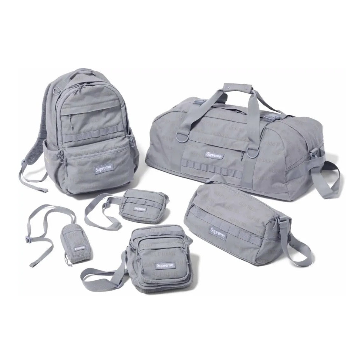A collection of gray Supreme bags including a backpack, duffel bag, and various smaller bags, featuring the Supreme Bag FW26.