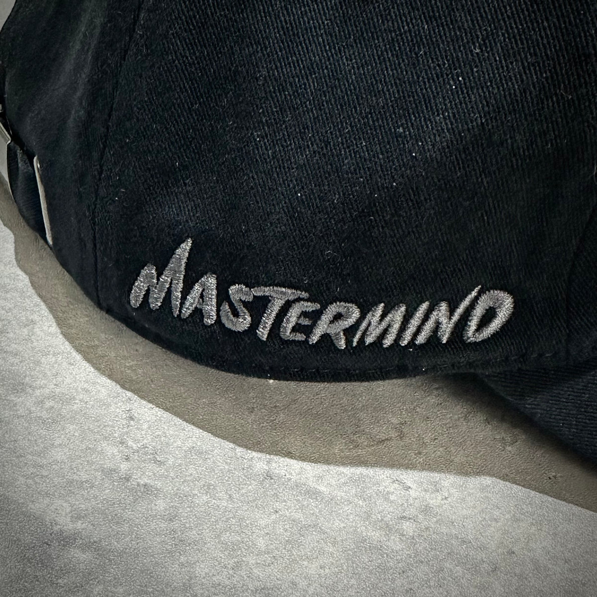 Wild Things x Mastermind World Tee Cap showcasing embroidered Mastermind logo on a black cap.