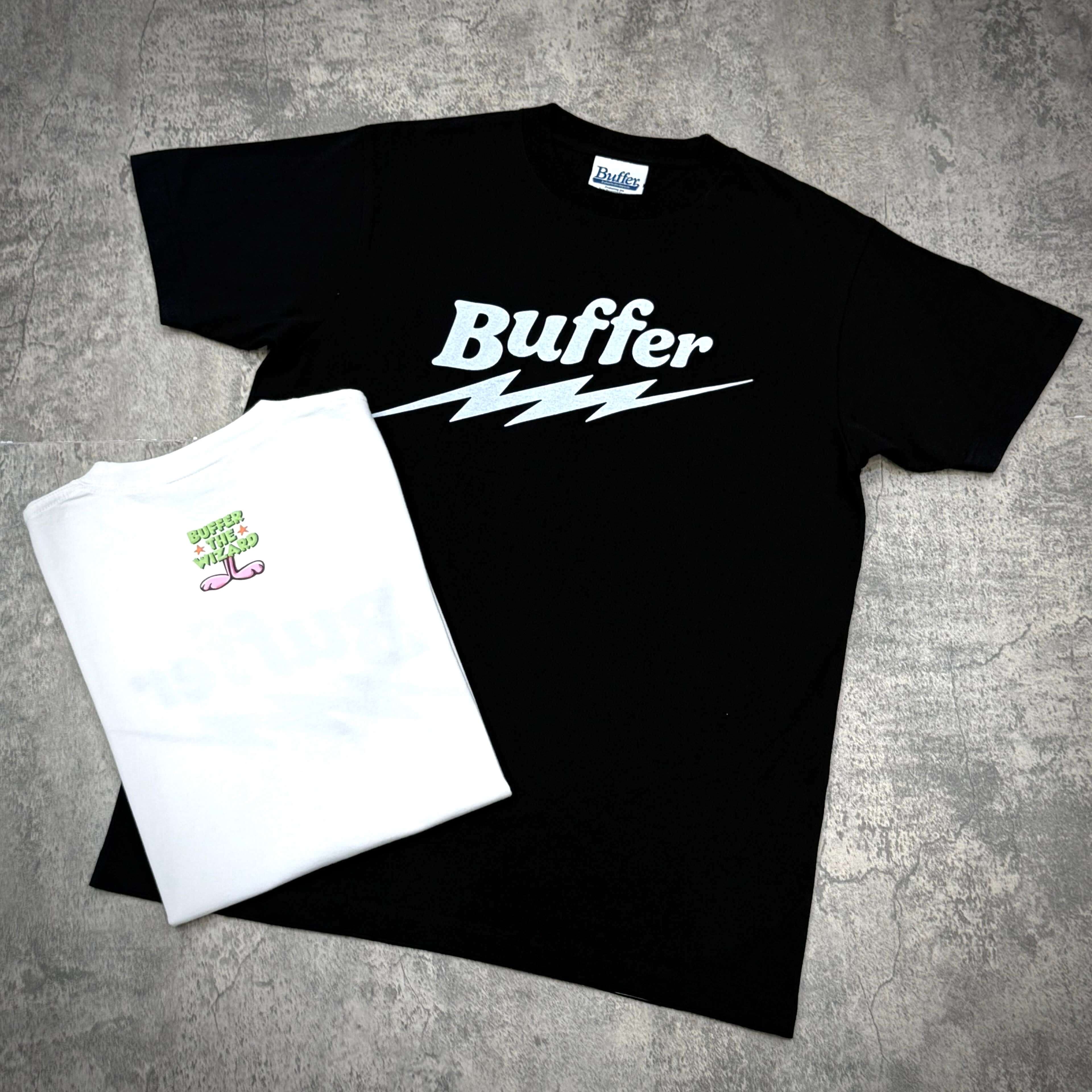 Black and white Buffer Lightning Wiz Tee displayed together on a textured surface.