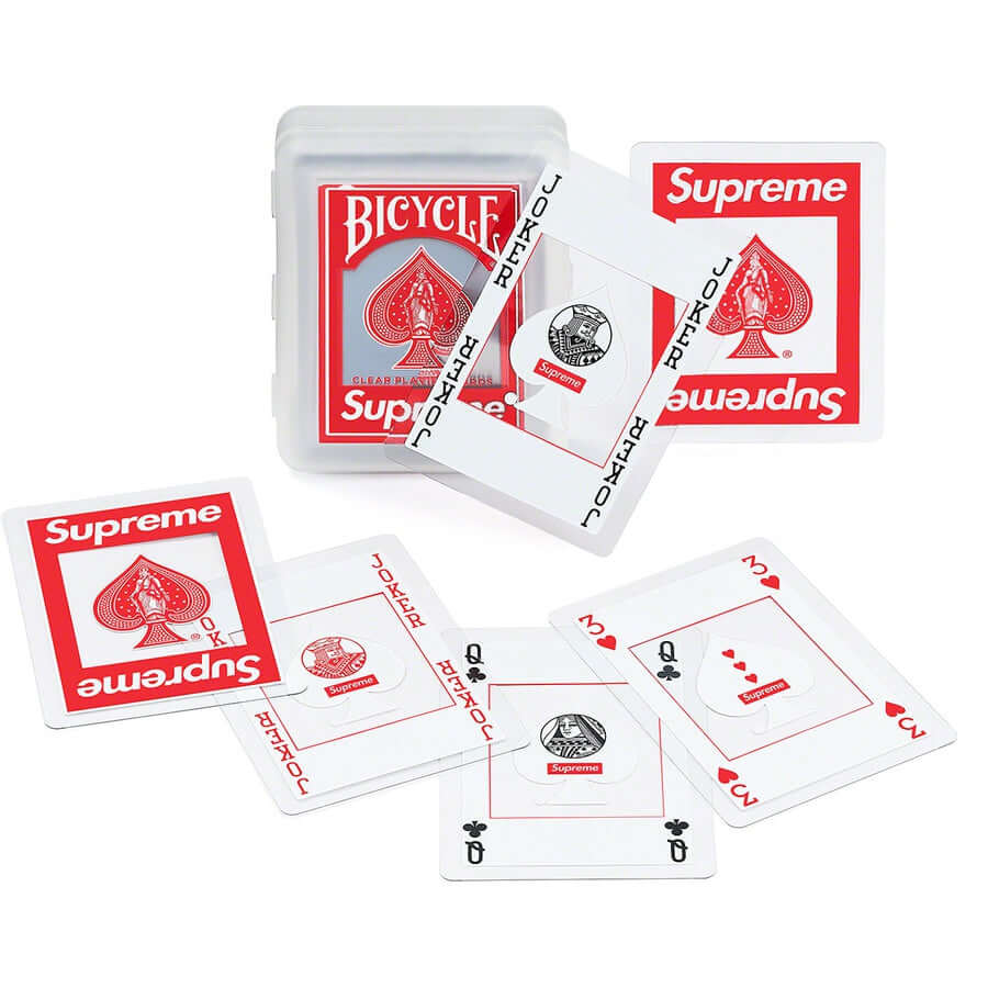 Supreme Bicycle Clear Playing Cards Red displayed with a transparent case, featuring unique card designs.